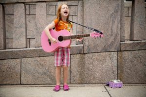 Red-haired girl plays guitar and sings