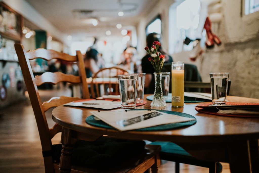 Wooden chair and table in a restaurant with glasses and candles